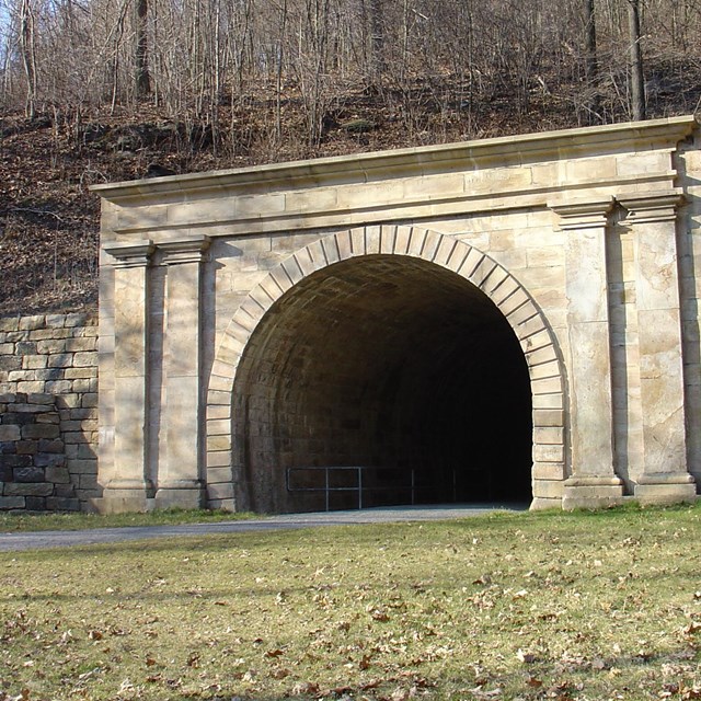 a small stone tunnel through a low mountain