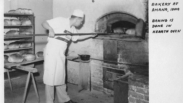 man taking bread out of the oven