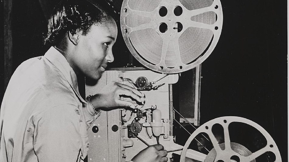 Photo of women working a projector.