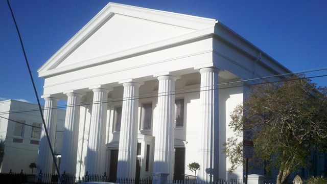 Black and white photo of a church with Greco-Roman columns. 
