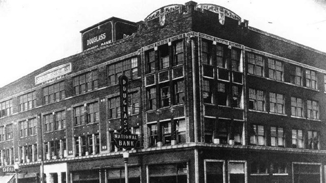 Photo of large brick building that served as a bank.