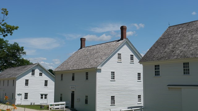 row of white clapboard buildings in Sabbathday Lake