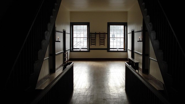 looking towards two windows from between two staircases