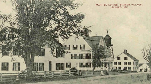 historic postcard of a street, with shaker buildings, in alfred