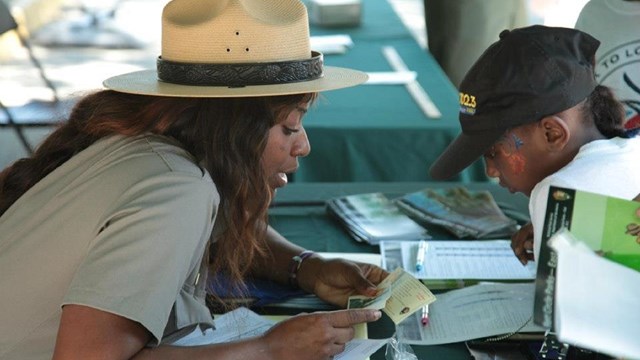 NPS ranger helping small child. NPS photo. 