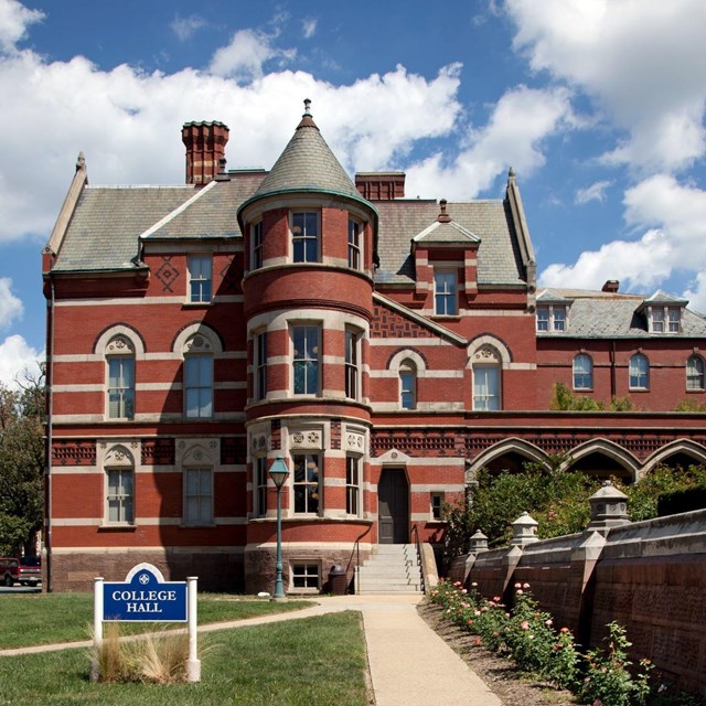 Photo of tall brick building with turrets. 