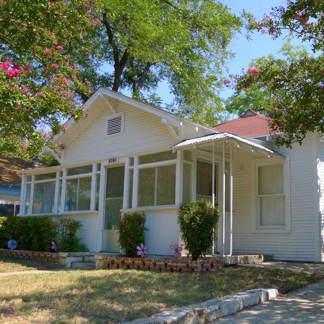 white ranch-style home with small porch.  Photo by Drewp4vp, CC BY-SA 3.0