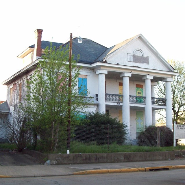 Photo of white two-story building with columns. Photo by Pubdog, CC0