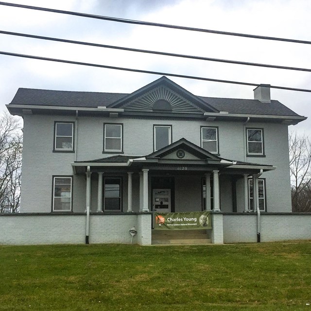 Two-story house with fence around it. NPS photo. 