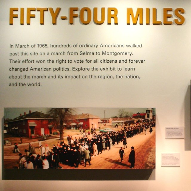 Color photo of exhibit panel with title '54 miles to freedom' above 3 photographs. NPS photo. 