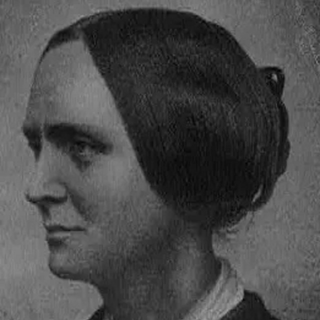 Black and white photo of a white woman with a Victorian era hairstyle