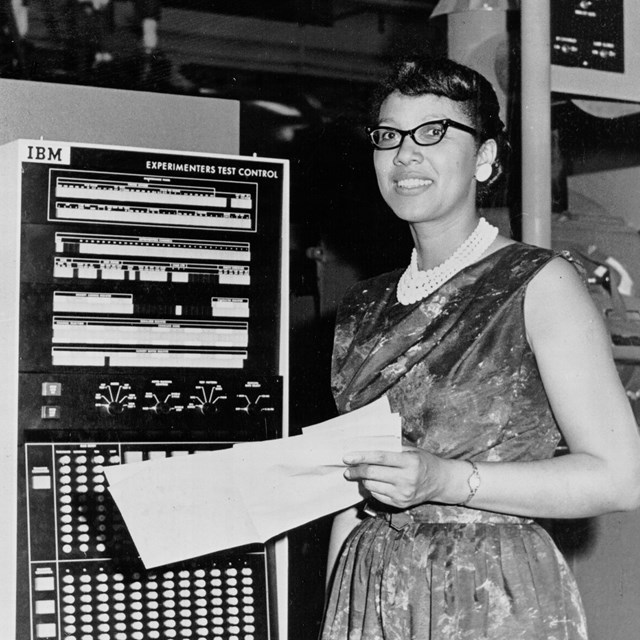 Woman standing by the computer. 