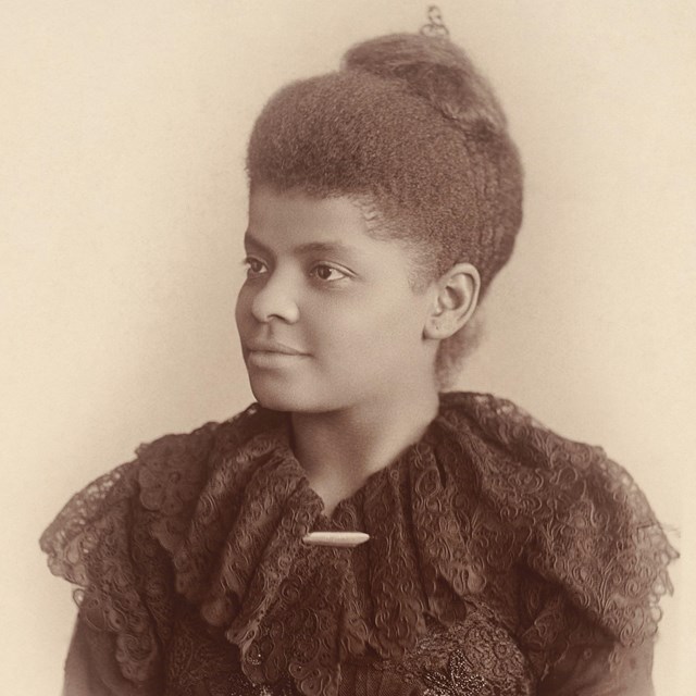 Woman in 19th century clothing posing for camera. 