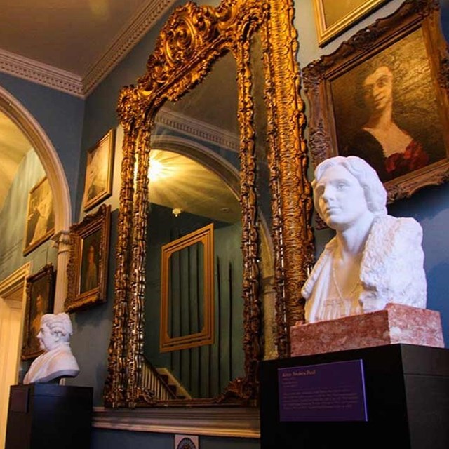 Interior of the entryway to the house with large mirror and busts. Courtesy National Woman's Party.