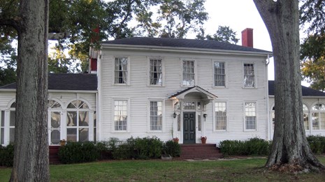 A large, white, two-story historic home.