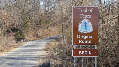 A brown sign "Trail of Tears, Original route," next to a dirt road.