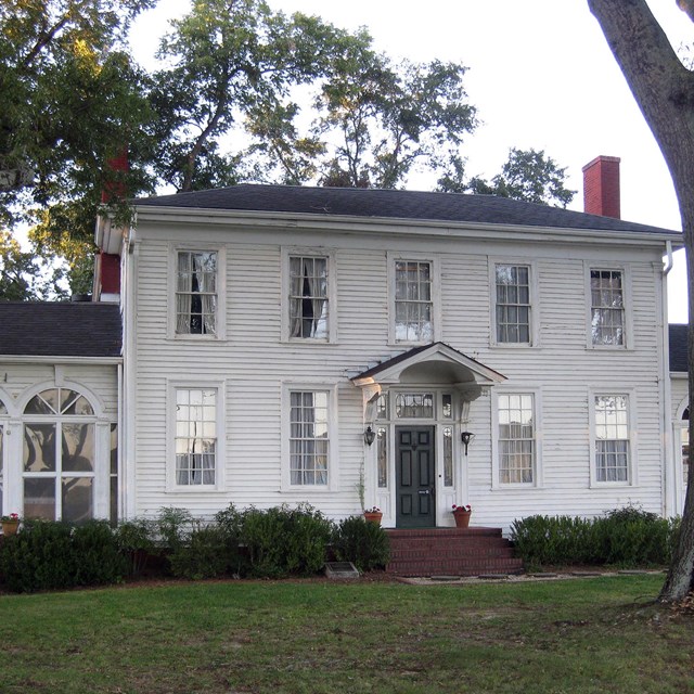 A large, white, two-story historic home.