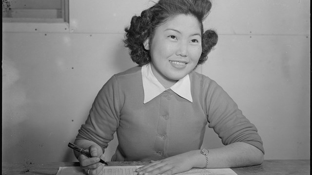 Mary Oshiro of the Tulean Dispatch, Staff, center newspaper, cuts a Japanese stencil.