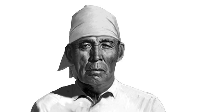 native man in white shirt and head covering