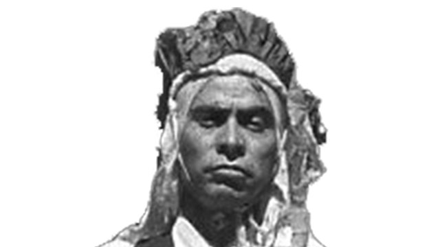 historic photo of native man with head covering, vest, and necktie