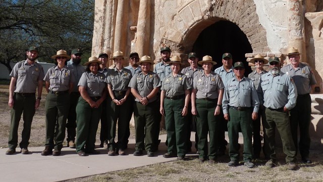 a dozen uniformed NPS staff standing in front of the mission church