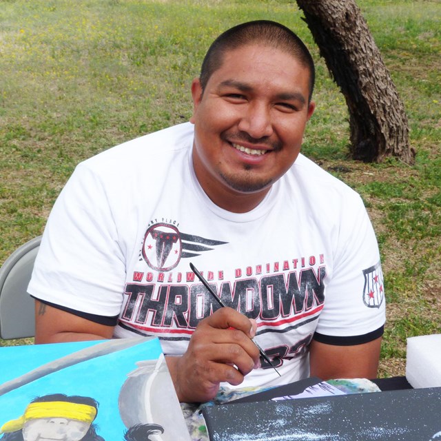 man smiling with paintbrush and canvas