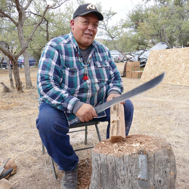 demonstrator with machete, carving a piece of cottonwood