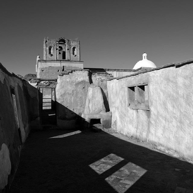 Black and white photograph of historical adobe structures.
