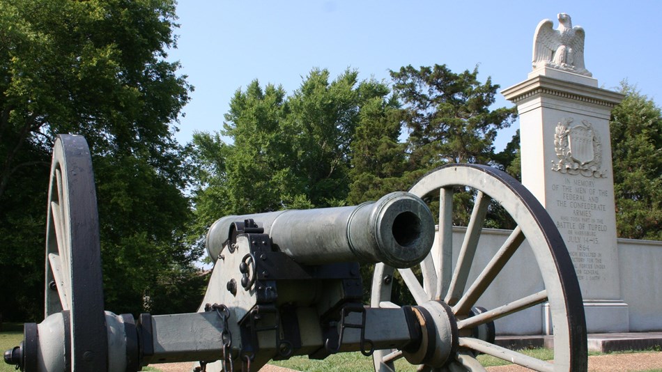 A cannon in front of the stone monument to the battle.