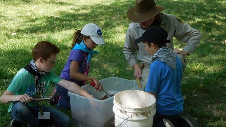 Junior Rangers practice archaeology digging techniques.