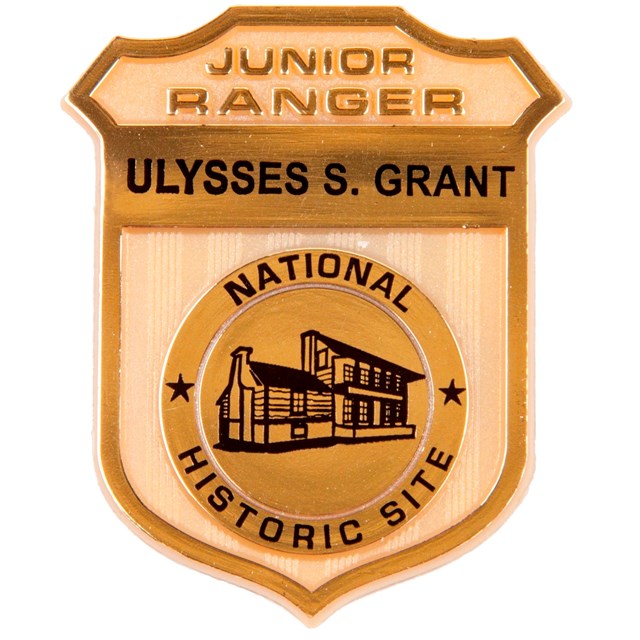 Gold Junior Ranger Badge with black text. 