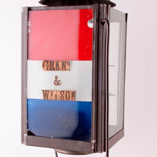 Rectangular shaped red, white, and blue lantern with text that reads 