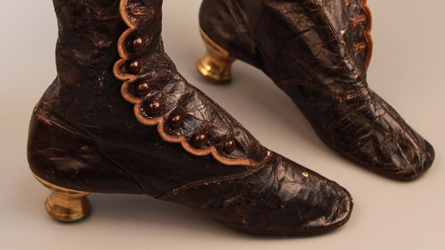 Pair of brown leather boots with gold heels