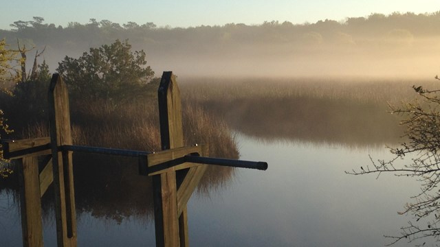 Fog lifts from a river at dawn.