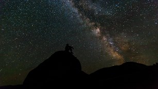 Stargazer's silhouette illuminated by stars