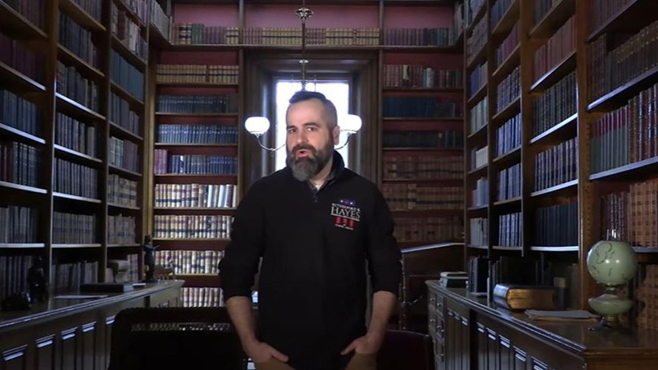 Historian Dustin McLochlin stands in a historic library.
