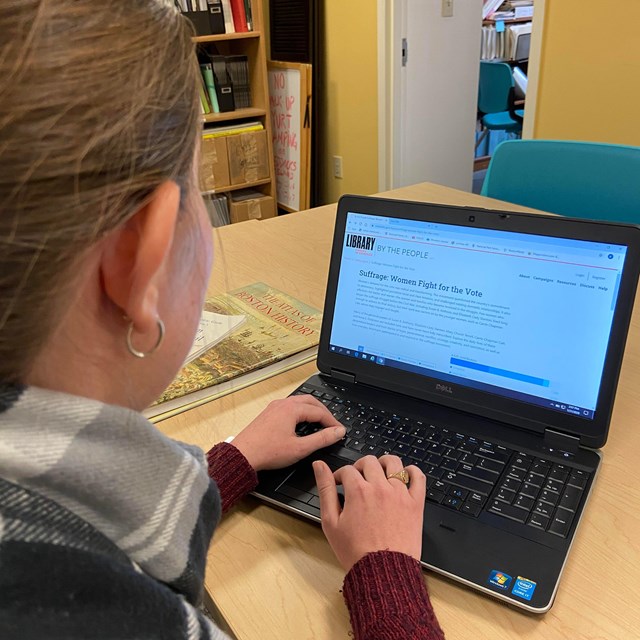 Individual sits in front of a computer