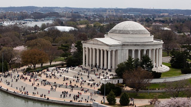 An aerial view of the Thomas Jefferson Memorial with several visitors walking up the steps