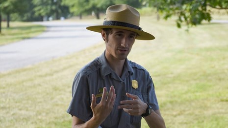 A ranger talks to visitors outside the Muhlenberg huts
