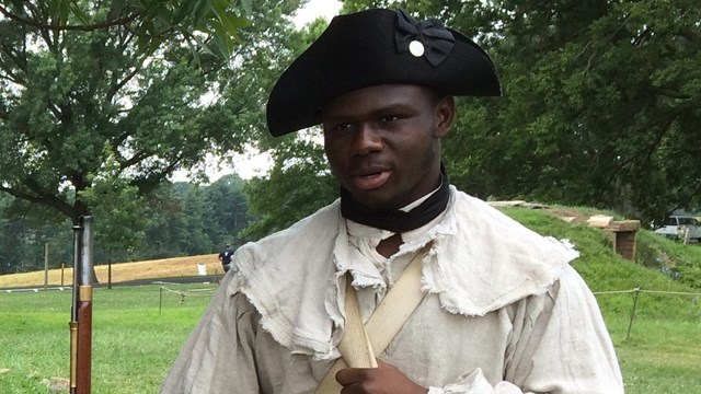 Black enlisted soldier speaking with visitors