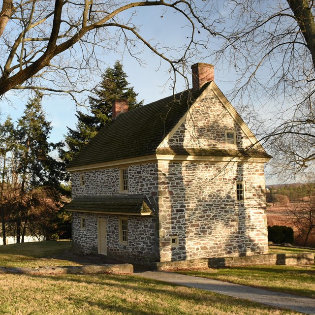 photograph of a small two story stone farmhouse