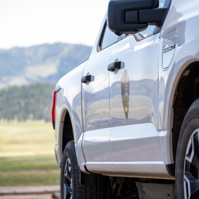 A closeup of a white National Park Service pickup truck.