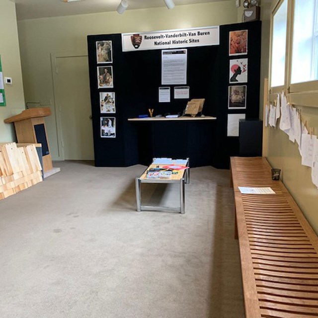 A large room with a bench and materials a table