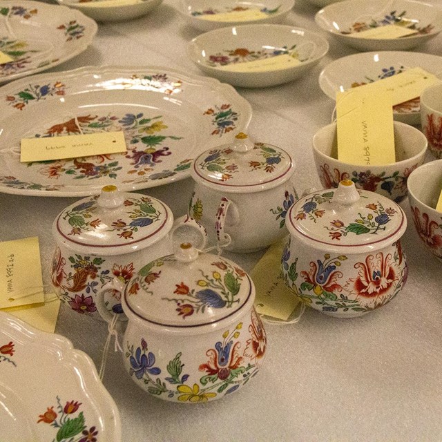 A group of china cups with floral painted decoration.