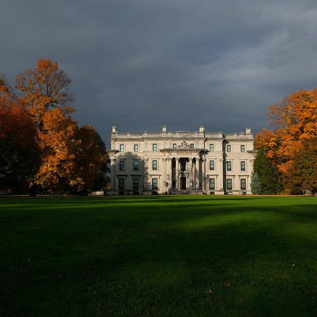 A grand house of stone amid a lush landscape.
