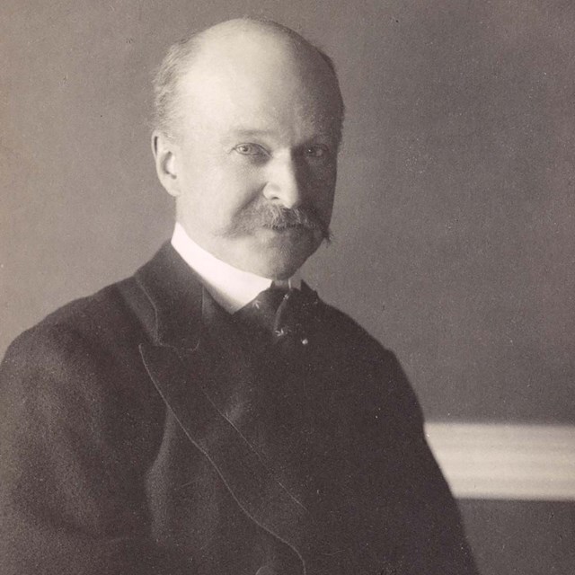 A man in a suit with an open book in his hand.