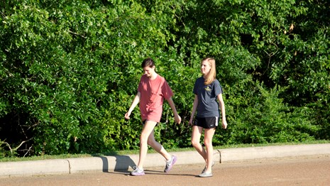 2 women walk the park tour road