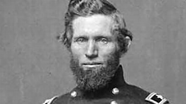 A black and white image of Isaac Quinby holding his sword and wearing a Union generals uniform.