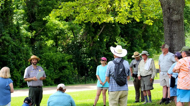 Park Ranger talks to group of visitors in the grass
