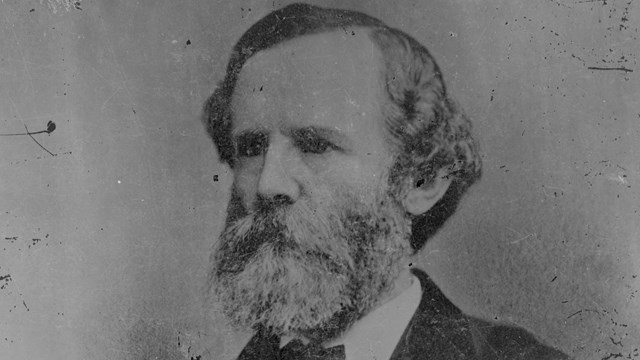 A black and white post-war image of Carter Stevenson in a suit.